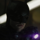 The Batman looks down at something exposed by his ultraviolet flashlight.